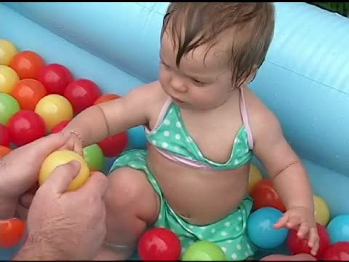 婴儿在游泳池里玩耍。