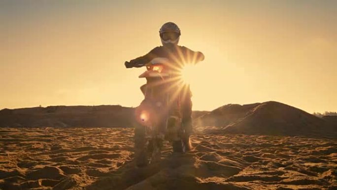 低角度拍摄的专业摩托车越野赛车手坐在他的FMX摩托车扭转全油门把手，并开始骑这极端的越野地形轨道
