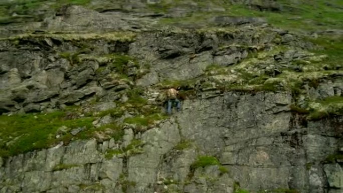 人在垂直的岩石上攀爬。极限训练。无人机的观点