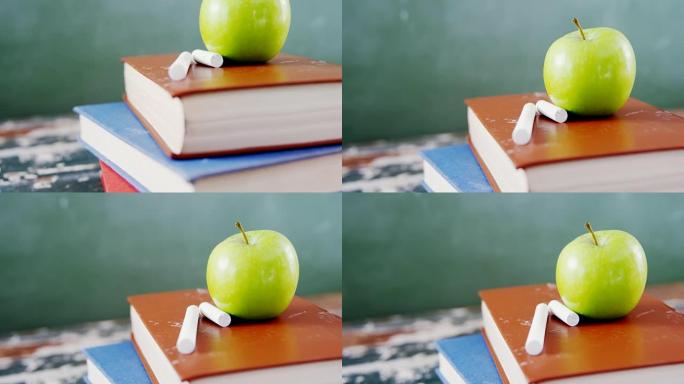 苹果和粉笔放在书堆上
