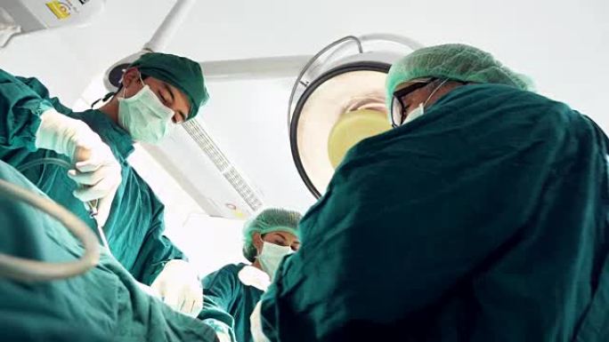 多民族外科团队在防护服中进行外科手术医院手术室，医疗队在现代手术室中进行外科手术。