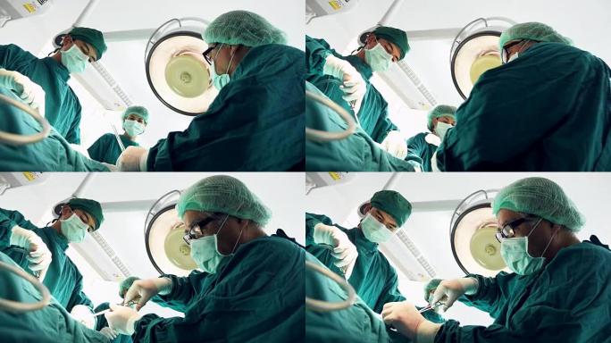 多民族外科团队在防护服中进行外科手术医院手术室，医疗队在现代手术室中进行外科手术。