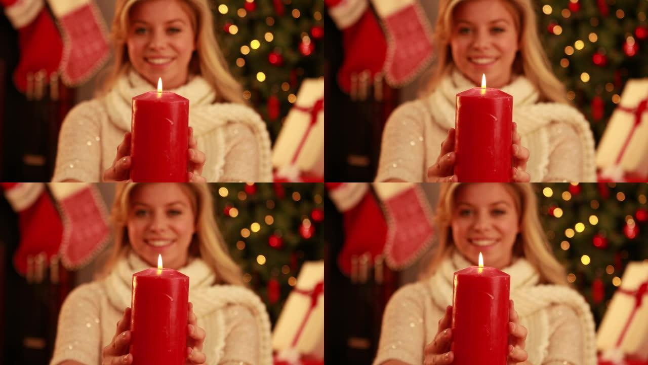 漂亮的金发女郎在圣诞节拿着蜡烛