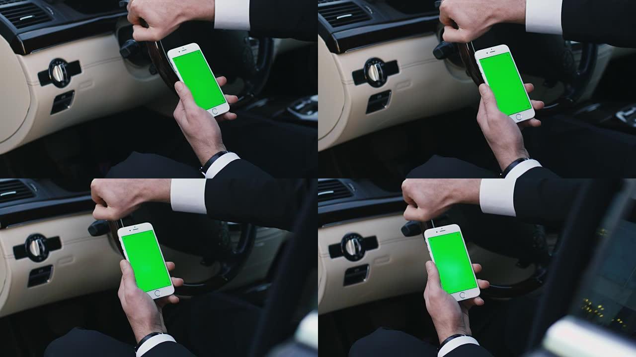 一个商人在汽车上使用带有模拟绿屏的智能手机的特写镜头。