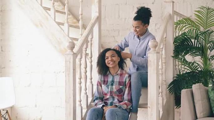 两个非洲裔美国卷发女孩姐妹会互相取笑卷发发型，在家玩得开心