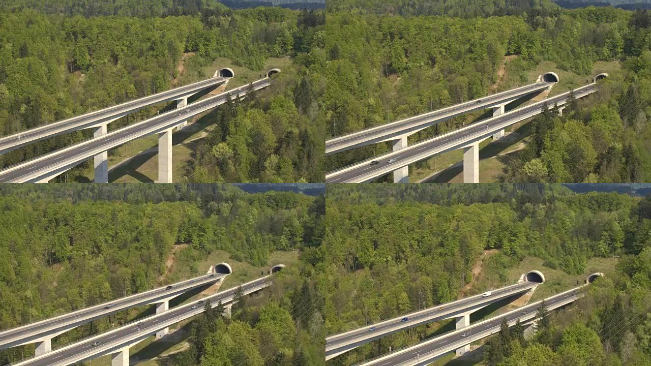 空中: 汽车和半卡车在大型高速公路高架桥上行驶并进入隧道