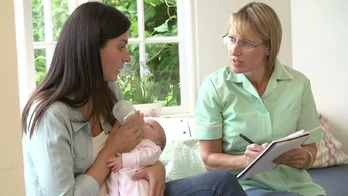 母亲在家里会见助产士时用奶瓶喂养新生女婴