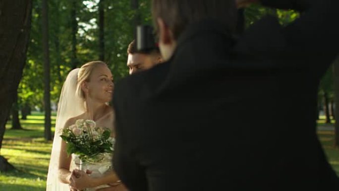新娘和新郎正在阳光明媚的公园里举行结婚照。