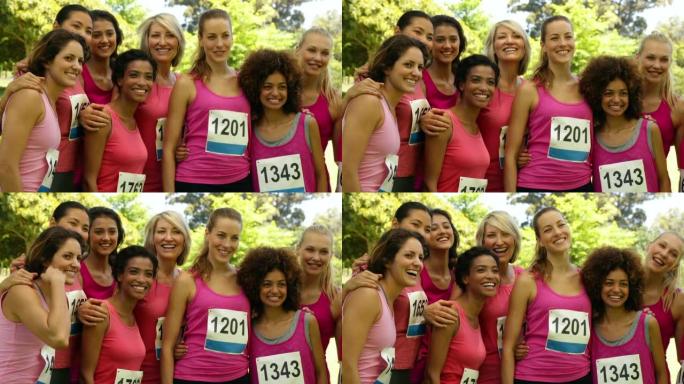 微笑的女人赛车粉红色以提高对乳腺癌的认识
