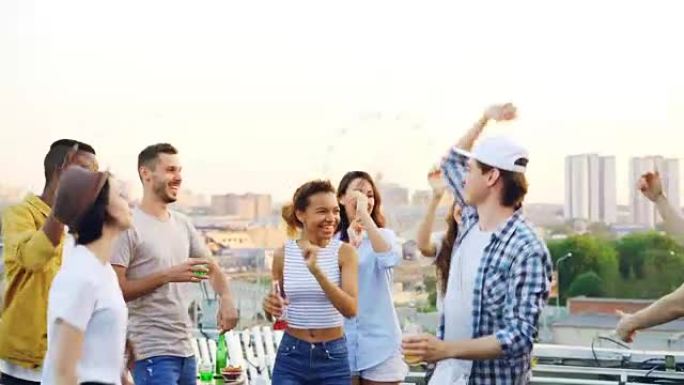 现代青年在屋顶上跳舞，欣赏音乐，而他们的朋友DJ则与戴着耳机的设备混在一起。派对、庆祝和有趣的概念。