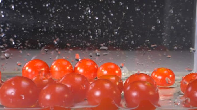 一堆西红柿掉入装有少量水的玻璃容器中的过程
