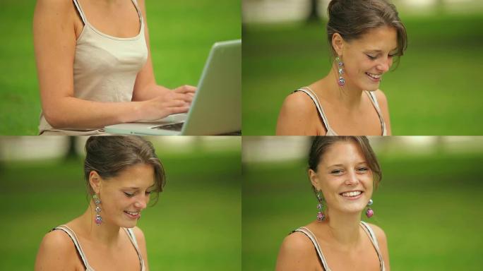 快乐的学生坐在草地上，用她的笔记本电脑