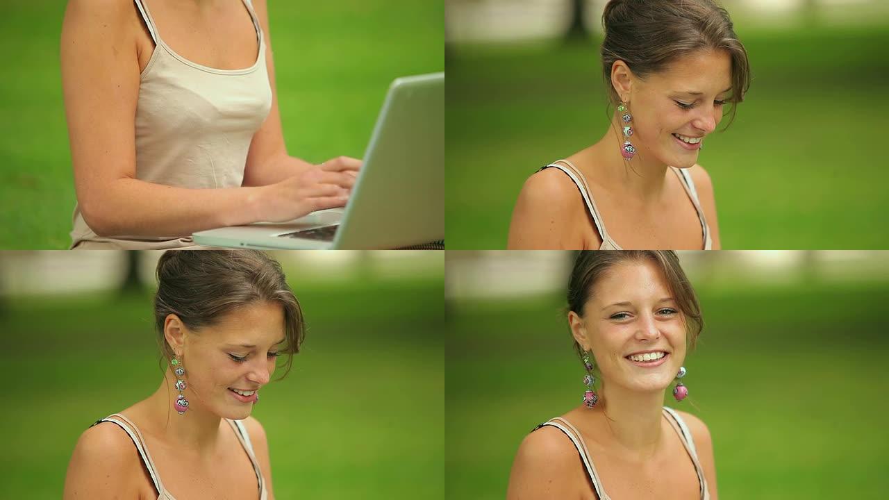 快乐的学生坐在草地上，用她的笔记本电脑