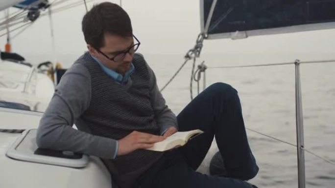 人在海里的游艇上看书。