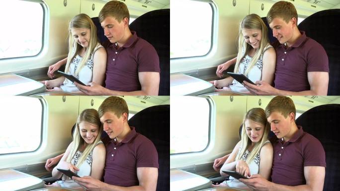 年轻夫妇在火车旅行中阅读电子书