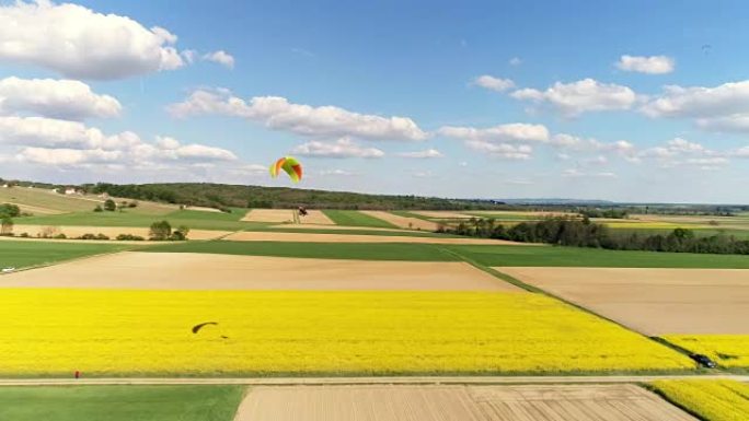 空中无人机视角滑翔伞，带降落伞，实时飞越乡村景观