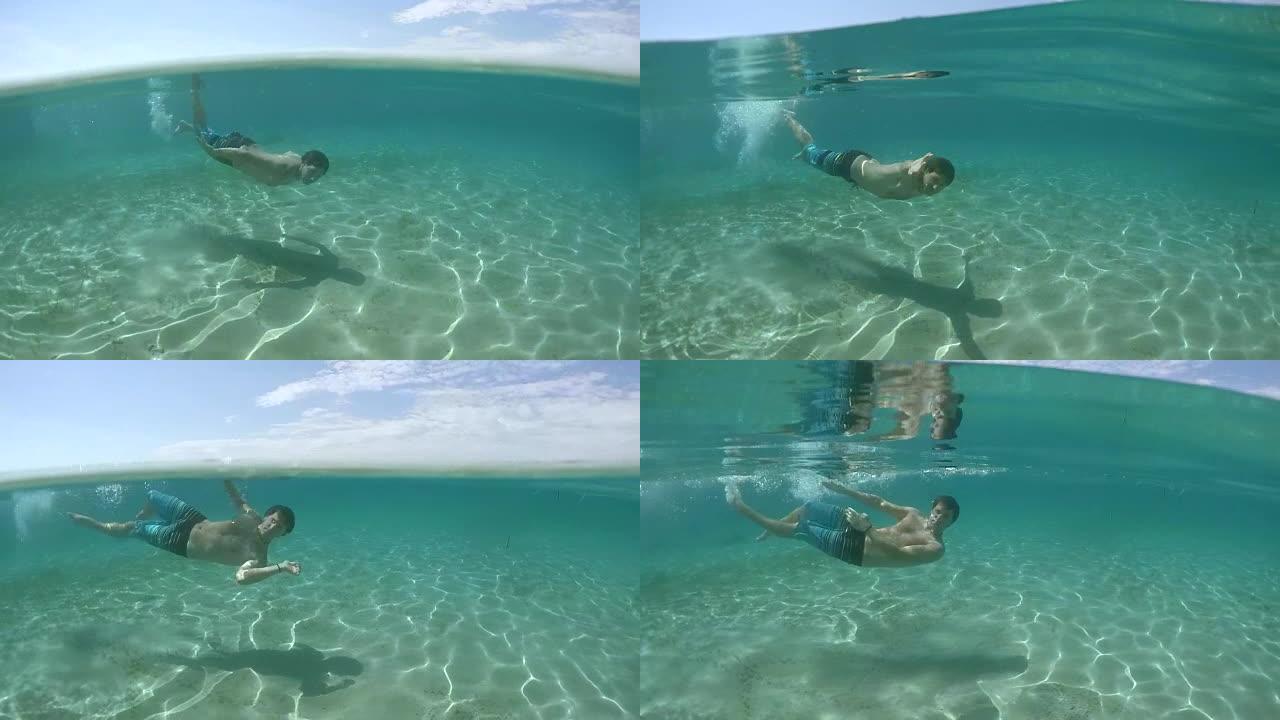 水下: 快乐的年轻人在令人惊叹的海底与沙质地板水下游泳