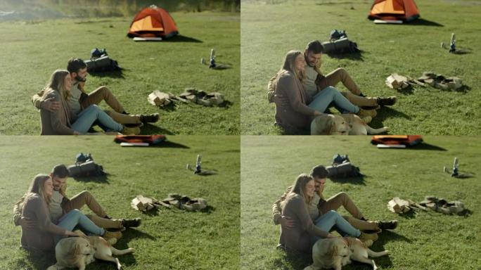 年轻的已婚夫妇在湖边和他们的狗玩得开心