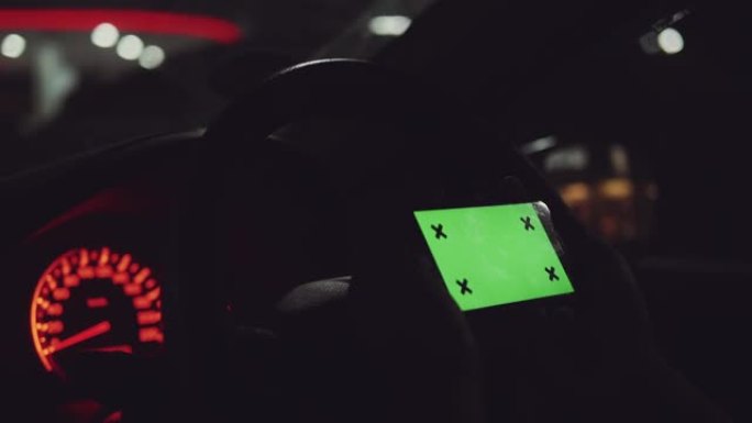 绿屏，晚上在汽车上使用智能手机的人。