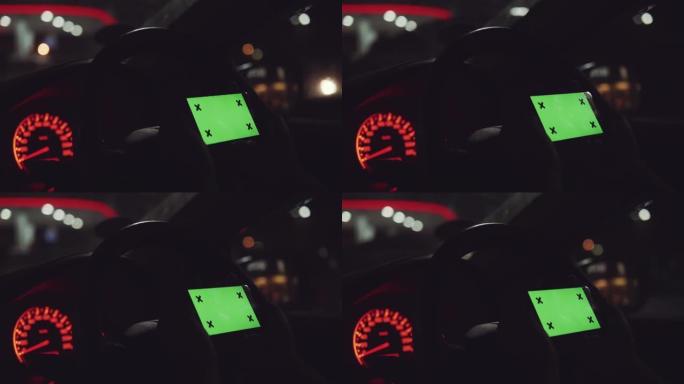 绿屏，晚上在汽车上使用智能手机的人。