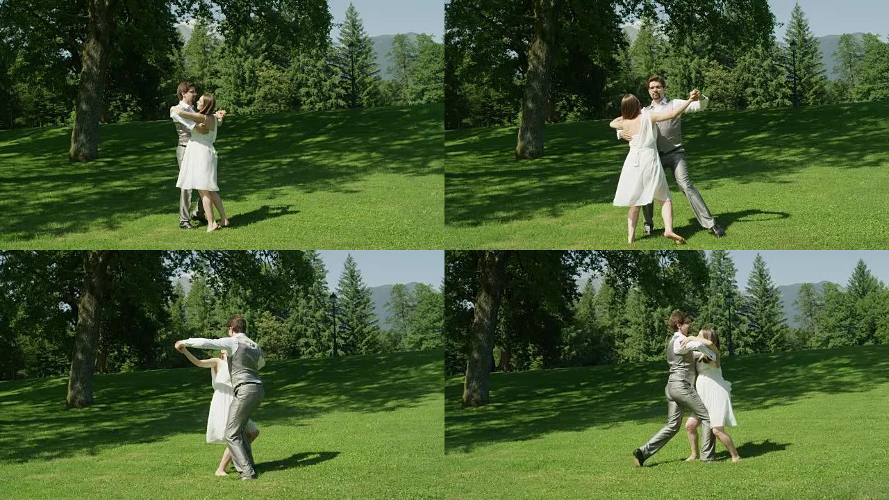 慢动作: 夏天，幸福的夫妻在美丽的阳光绿色公园里跳舞