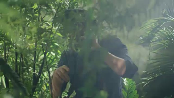 戴帽子的冒险家在丛林森林使用手机通话。