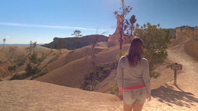 年轻女子游客徒步旅行，欣赏布莱斯峡谷的景色
