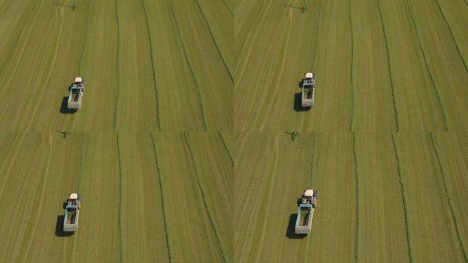 空中: 农田拖拉机上的农民在牧草车上收集饲料