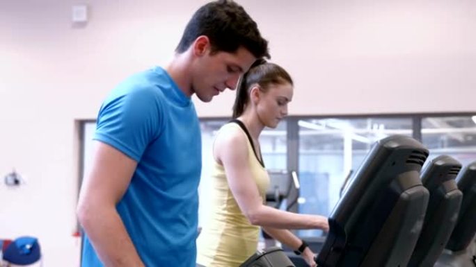 夫妇在健身房的跑步机上跑步