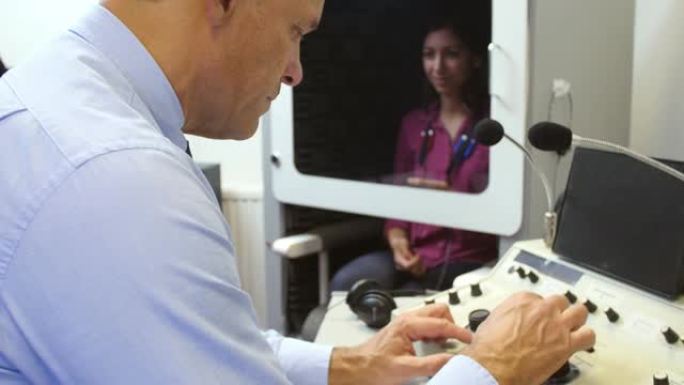 听力学家对女性患者进行听力测试