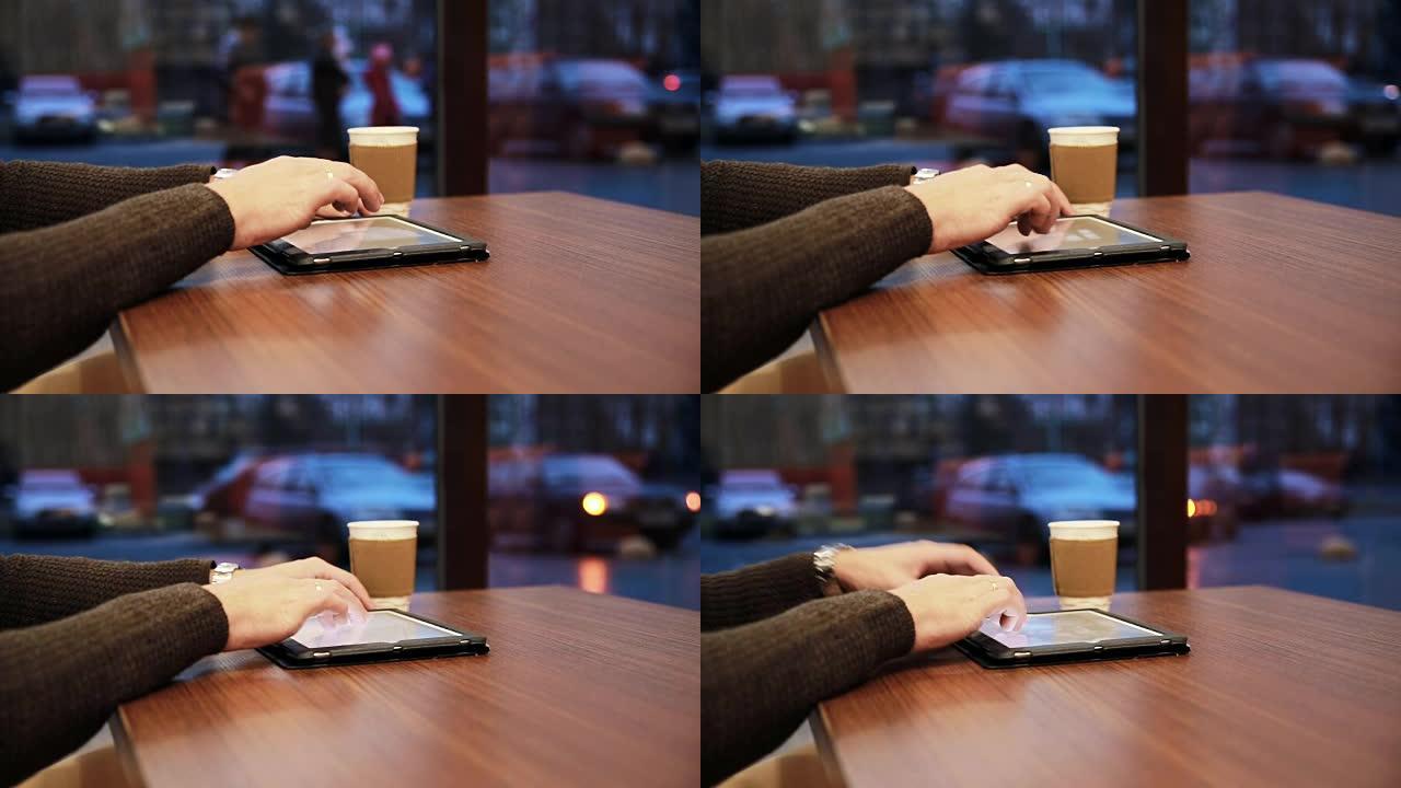 咖啡馆中使用平板电脑触摸屏的人