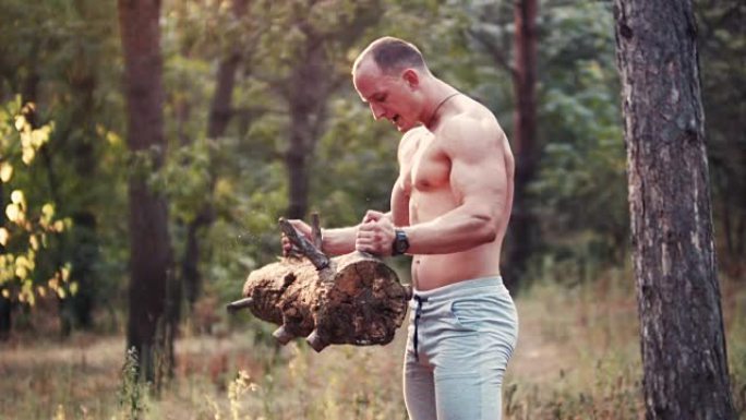肌肉裸露的运动员在森林里做二头肌卷
