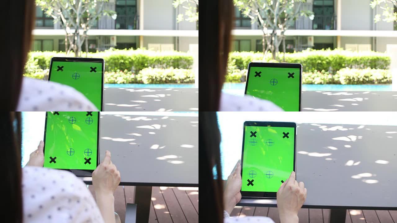 女人的手拿着平板电脑绿屏