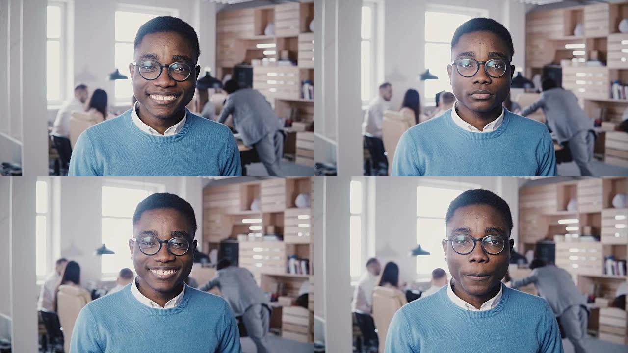 年轻英俊的非洲裔美国商人戴着眼镜对着镜头微笑。潮男时尚白领摆4K造型