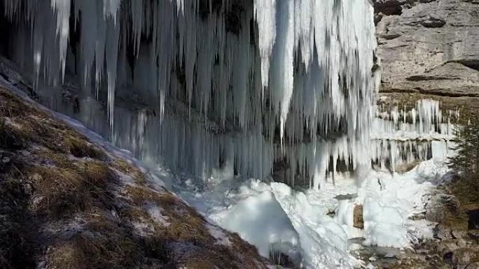 空中特写: 冬季高山瀑布壁上令人惊叹的冰冻冰柱