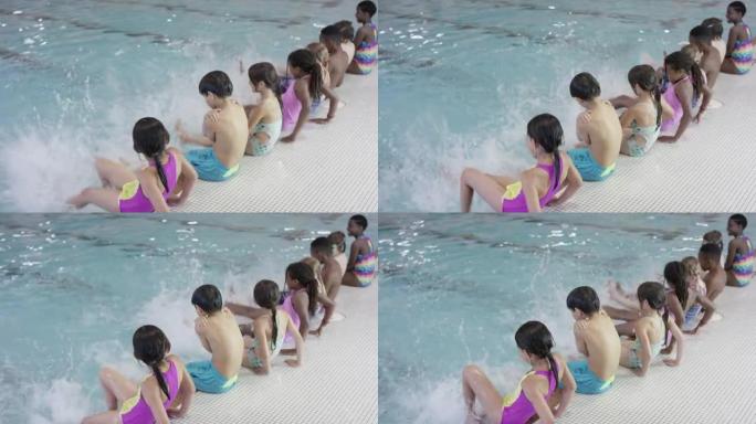 多种族的儿童在游泳池里踢腿
