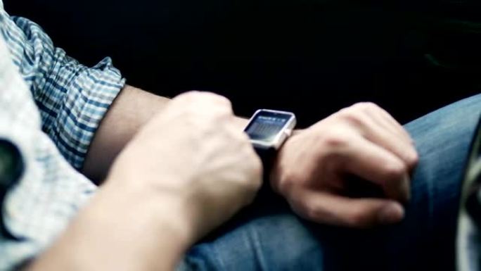 坐在汽车上使用智能手表的人的手