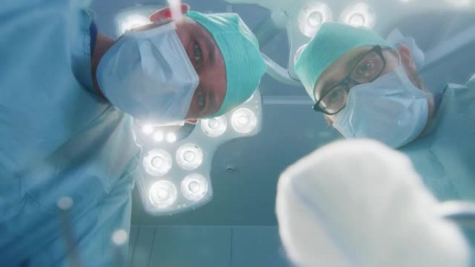 低角度镜头视点患者视图: 两名专业外科医生拿着手术器械开始手术。