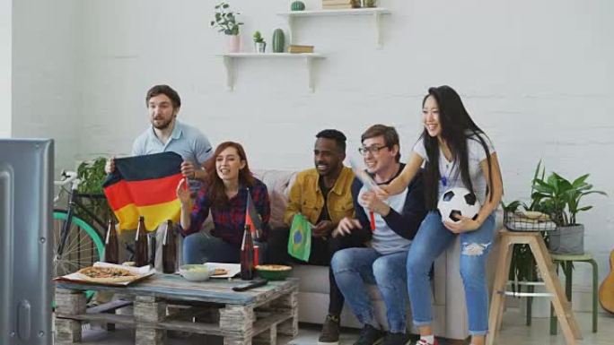 国际青年朋友在家里一起看奥运会比赛。有些人对德国队获胜感到高兴，但巴西人很失望