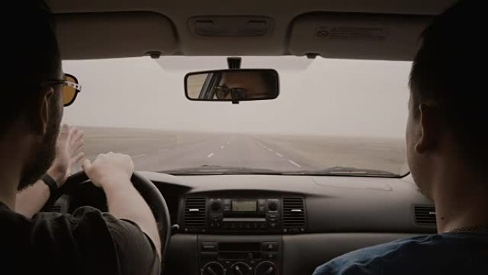 车内视图。两个人开车穿过乡间小路。戴墨镜的男性开车和与朋友聊天