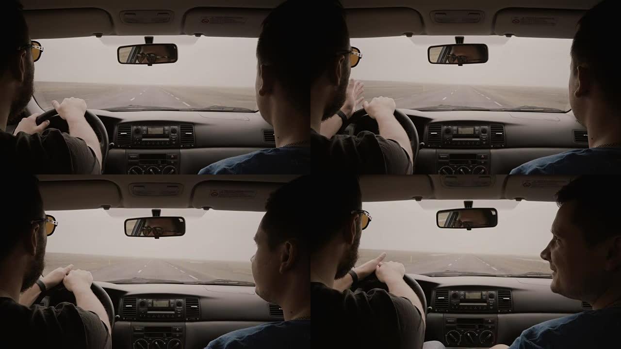 车内视图。两个人开车穿过乡间小路。戴墨镜的男性开车和与朋友聊天