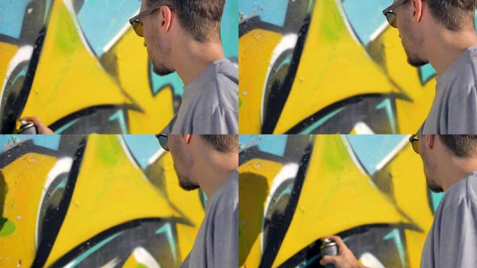 涂鸦艺术家正在墙上的黄色字母附近画一条黑线。