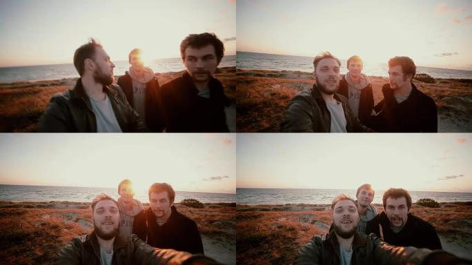 日落时，三个家伙站在覆盖着干草的沙丘上，一起自拍