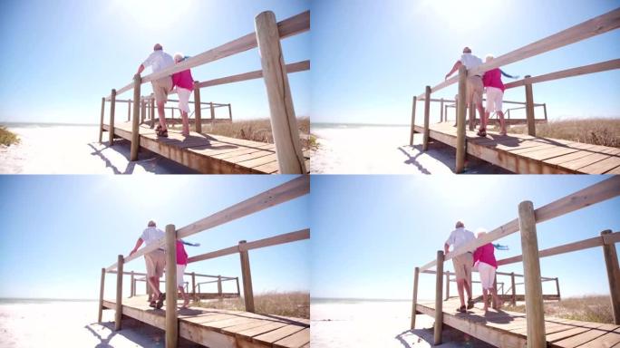 老年成年退休夫妇在海滩上牵手