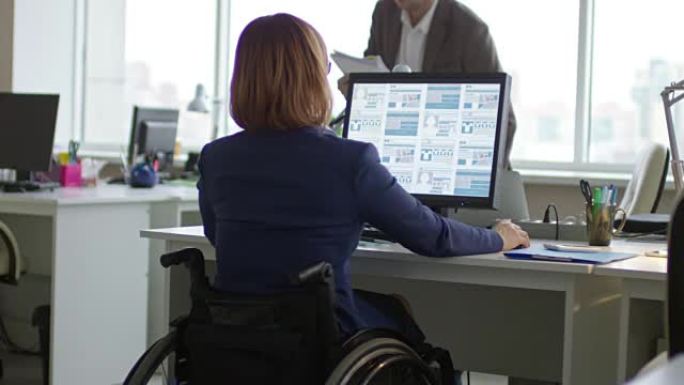 轮椅上的女人与同事一起在办公室工作