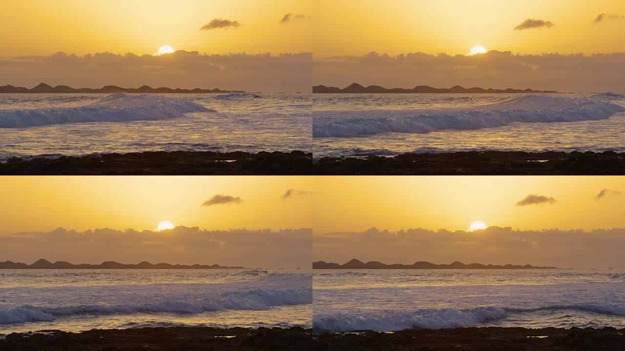 慢动作: 当太阳落在云层后时，反射的小海浪破裂。