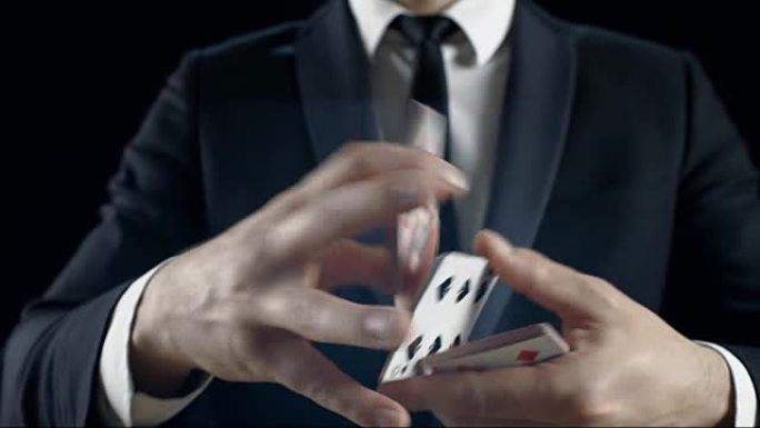 一个合适的魔术师的手表演技巧的特写镜头。背景是黑色的。