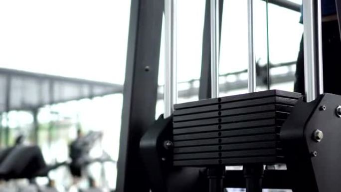 两张在健身房进行机器锻炼的特写镜头