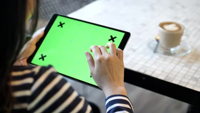 在咖啡厅使用带绿屏的数字平板电脑，水平
