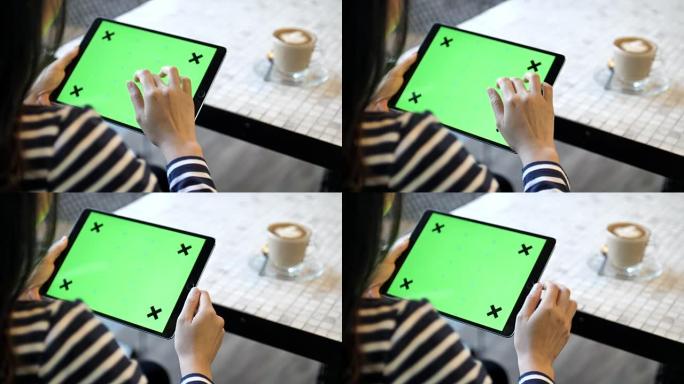 在咖啡厅使用带绿屏的数字平板电脑，水平
